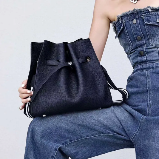 A lady holding a black bag on her thigh