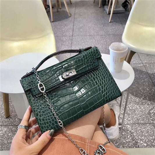 Women’s luxury handbag in Kelly silhouette, featuring gold hardware and a detachable crossbody strap.

